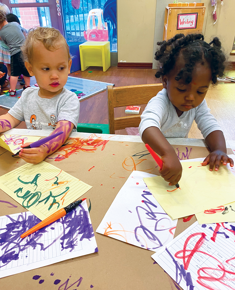 two young children coloring in school