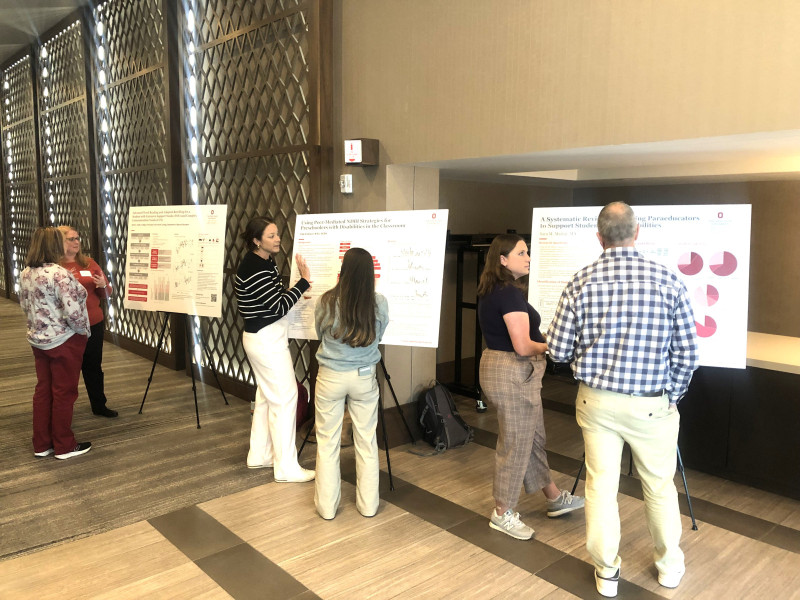Students showing research posters at symposium