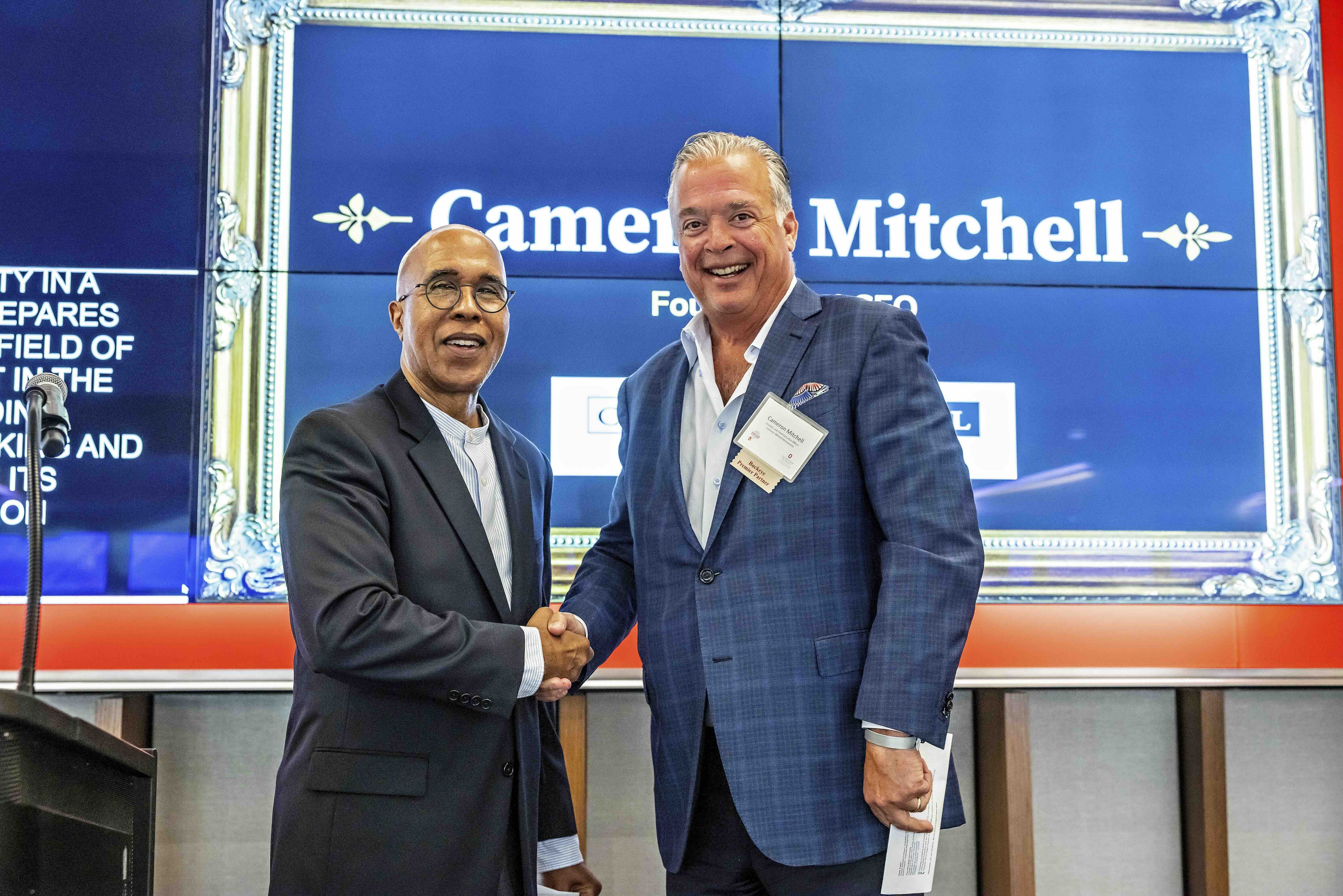 Dean Don Pope-Davis of EHE shaking hands with restaurant owner Cameron Mitchell