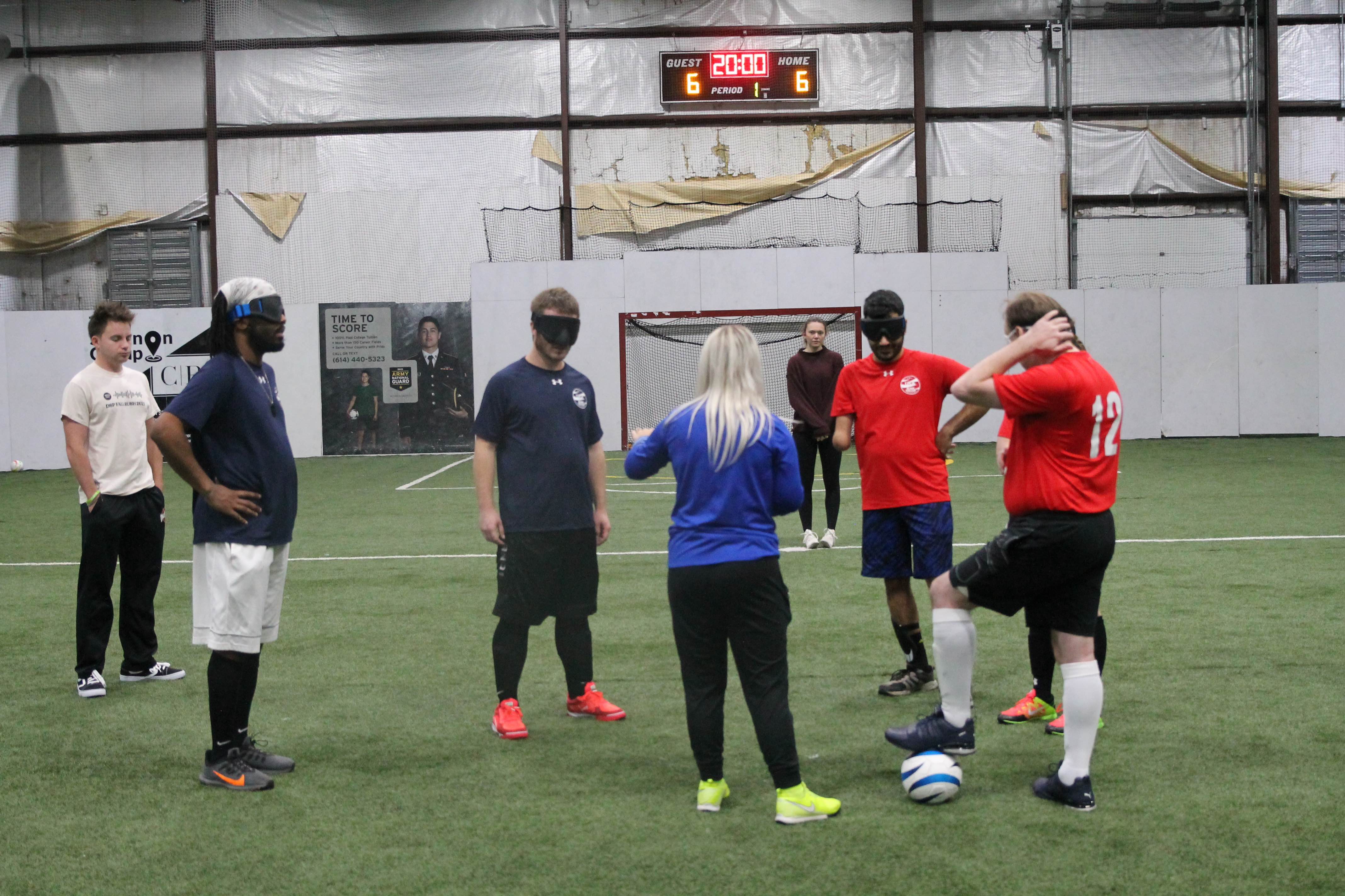 visually impaired soccer players listening to coach
