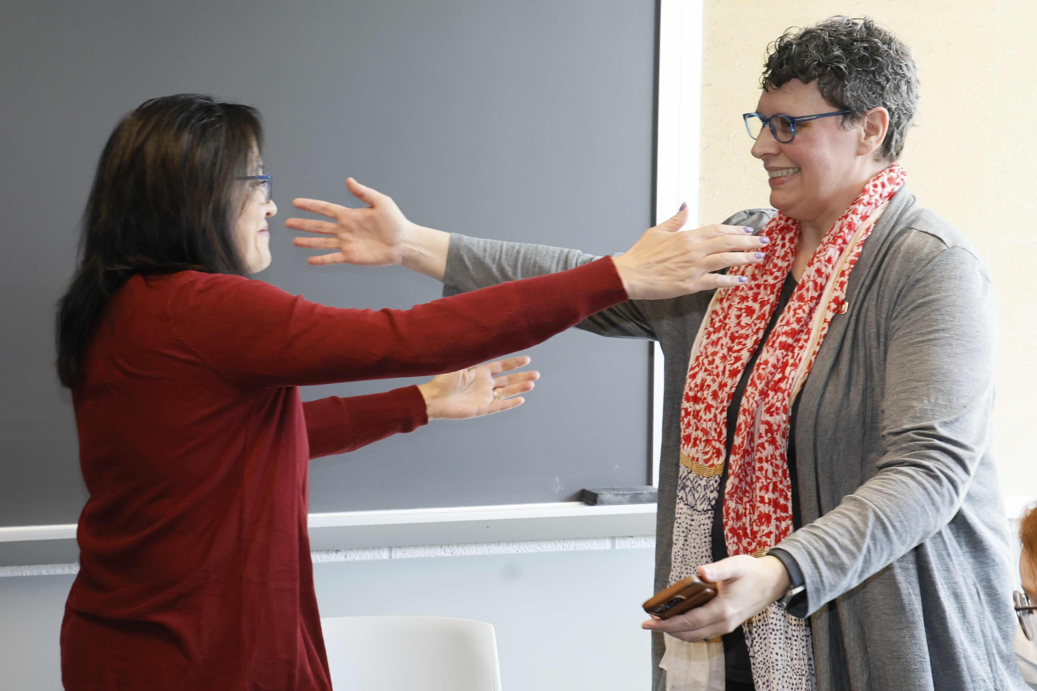 Shirley Yu hugs another faculty member celebrating her award