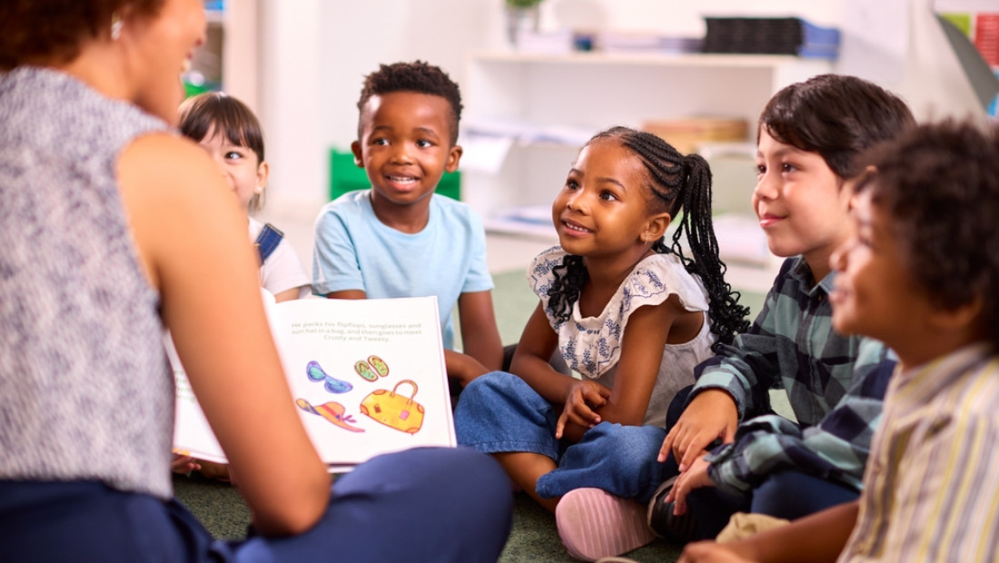 female teacher reads to elementary students