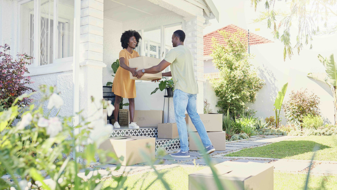 Couple moving boxes into a new house