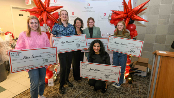 Ohio State students holding large checks at scholarship celebration