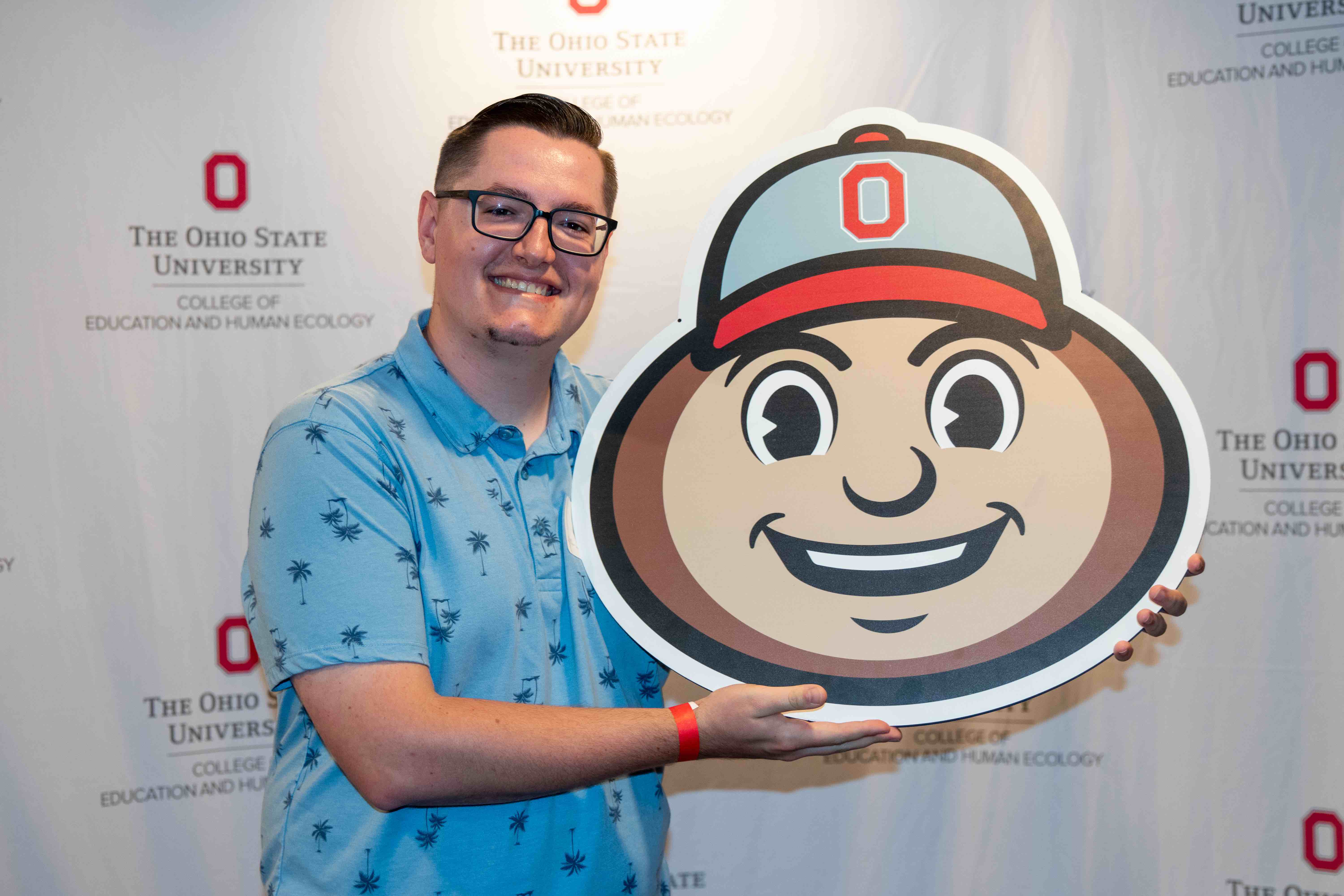 Ohio State EHE alumni at HESA reunion holding a Brutus cutout