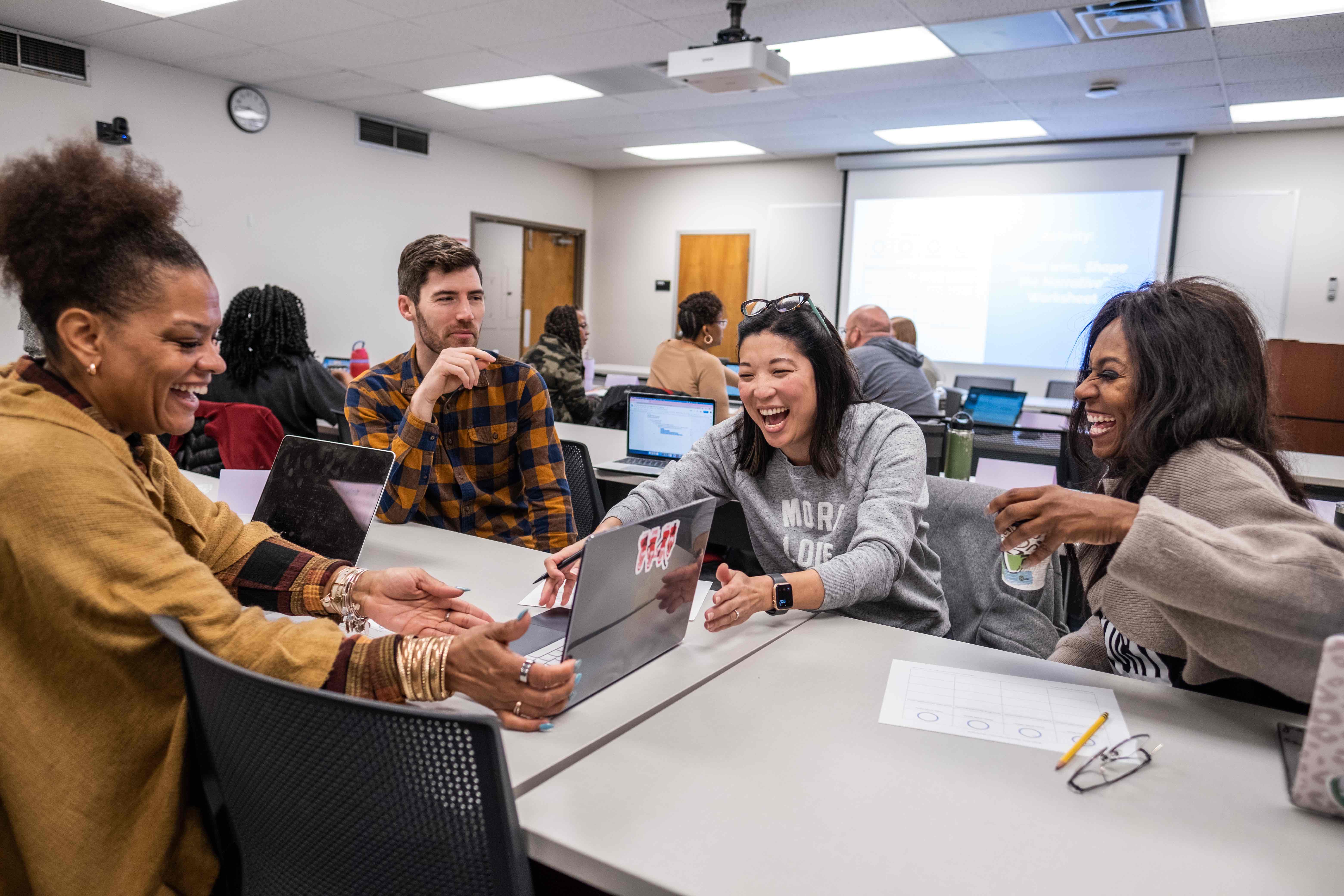 Educators in a classroom laughing together